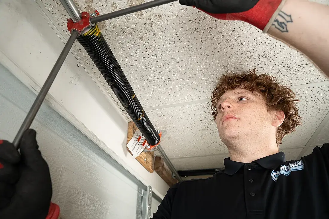 Torsion spring being wound on a garage door shaft