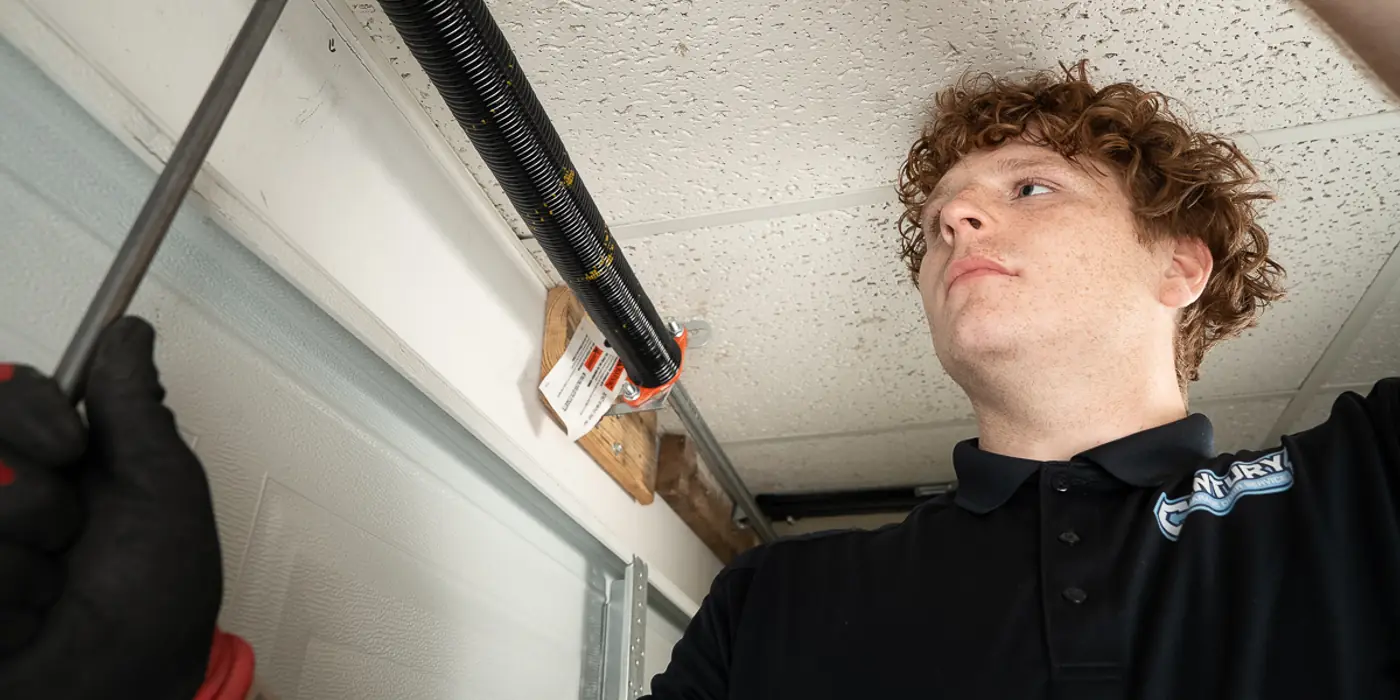 Century technician replacing a broken garage door torsion spring